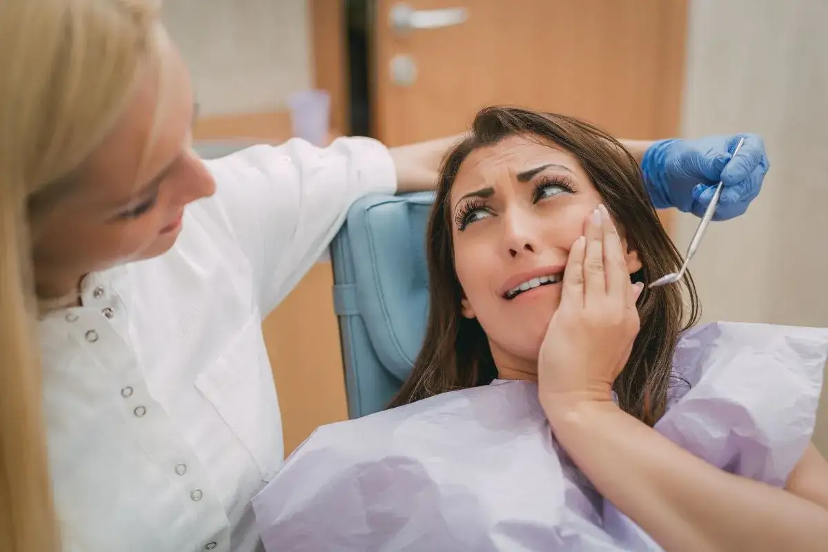 Kobieta cierpi z powodu bólu zęba, który daje jej wysokie ciśnienie. Dentystka próbuje jej pomóc.