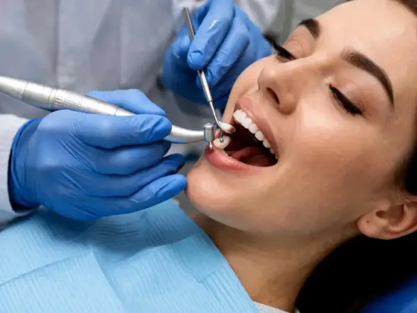 Dentysta zakłada plombę w zębie pacjentki.